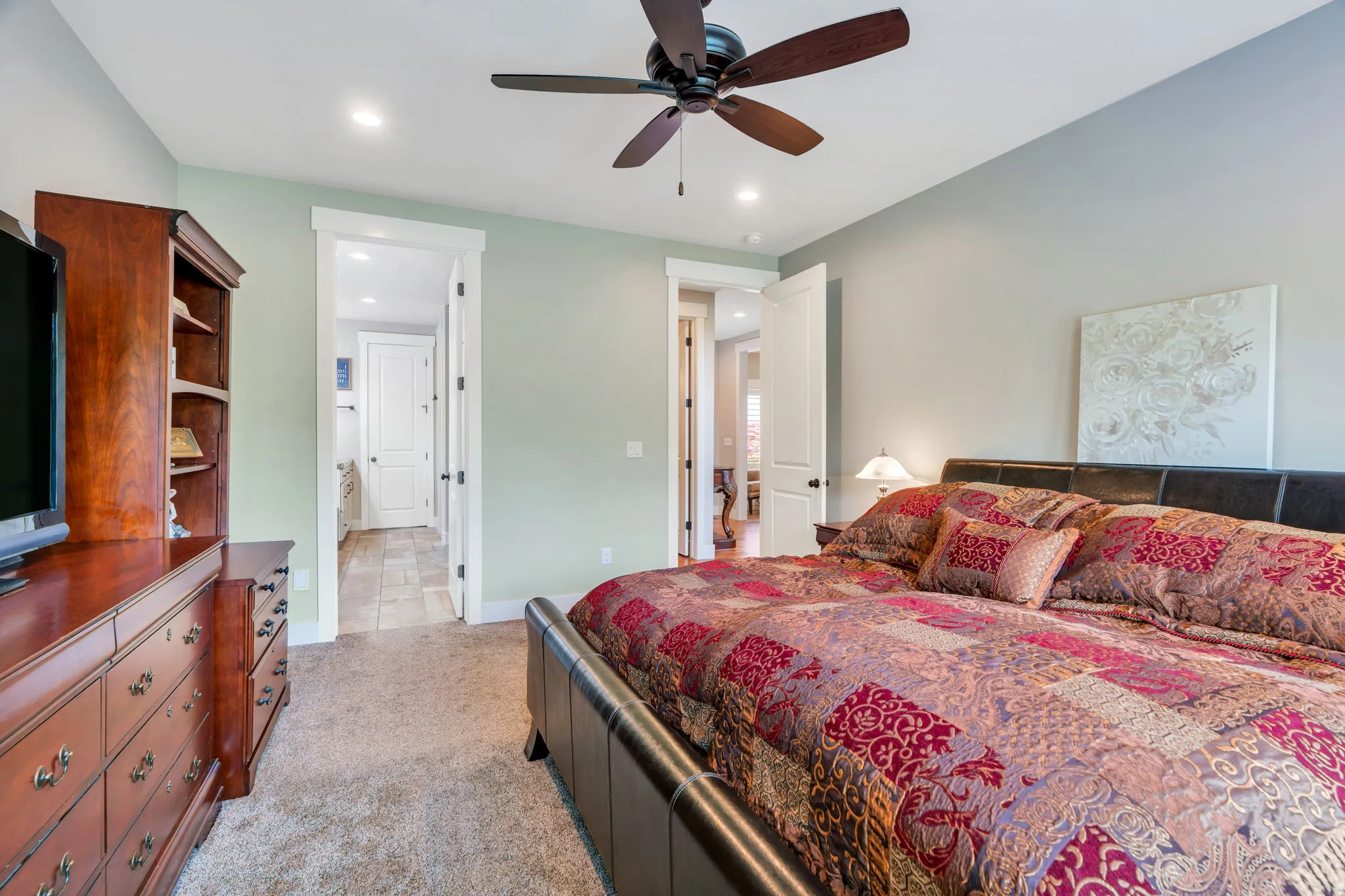 Spacious bedroom featuring neutral carpeting, recessed lighting, and a ceiling fan