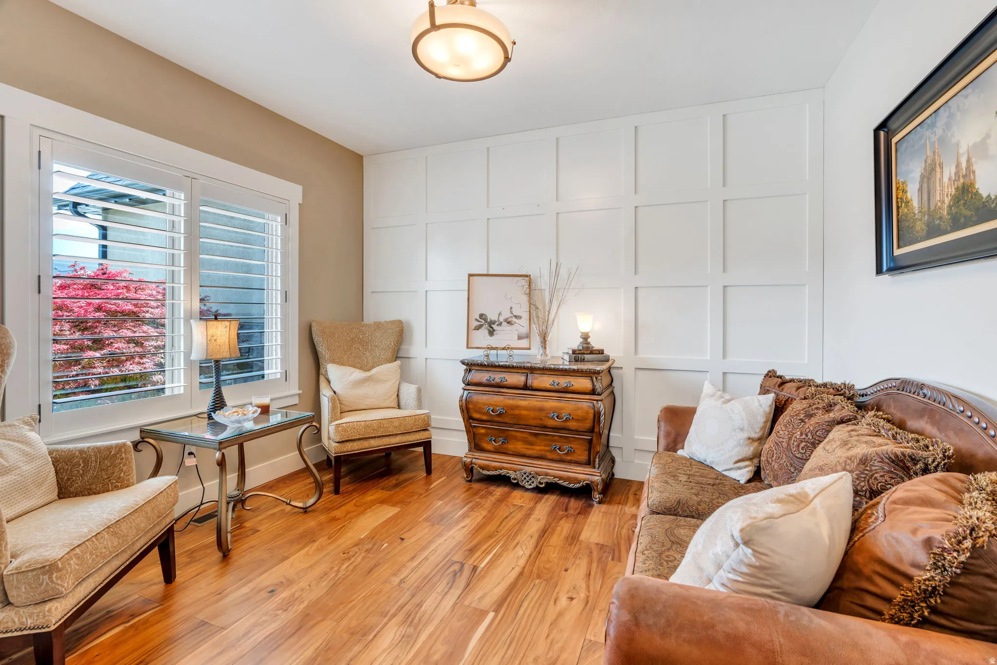 Interior room featuring wood-finish flooring, white wainscoting, and neutral-toned wall paint