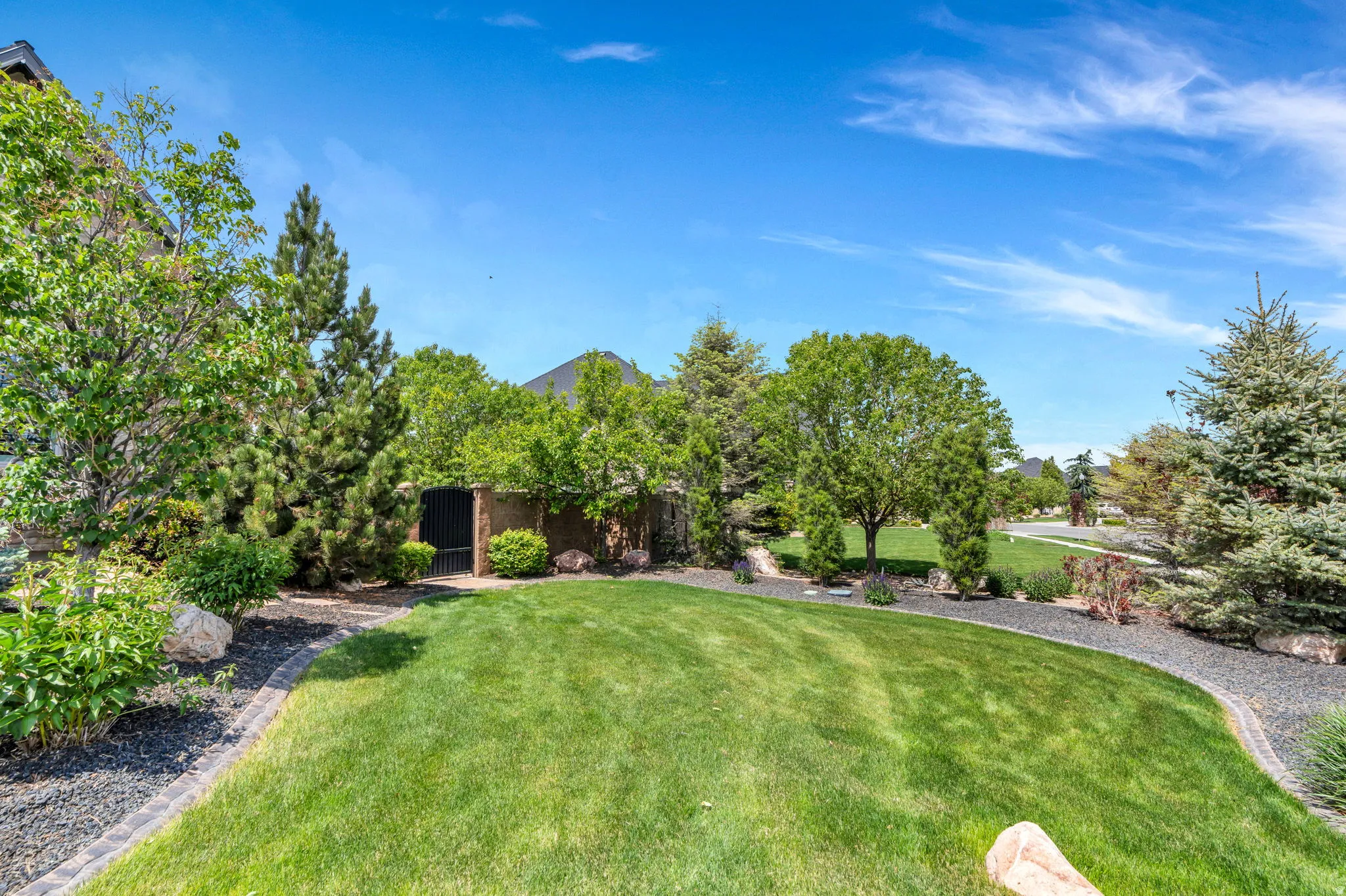 Expansive green lawn framed by mature trees and landscaping
