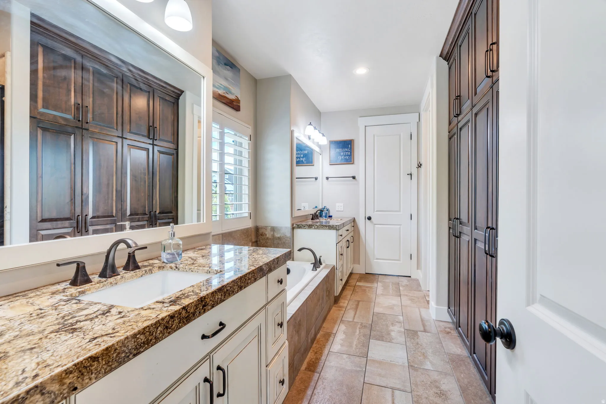 Bathroom featuring a large vanity with a granite countertop, undermount sink, and oil-rubbed bronze fixtures
