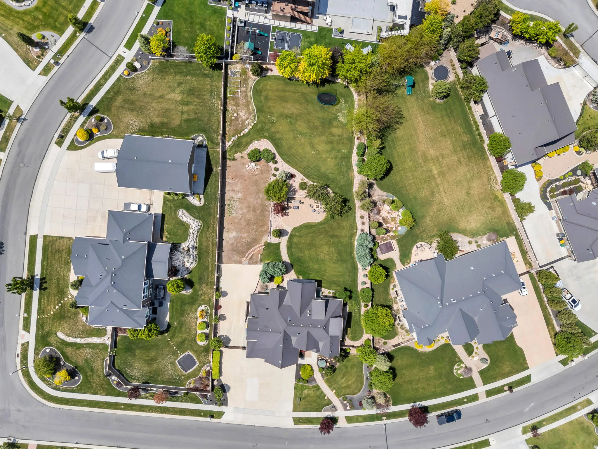 Aerial perspective showcasing a residential property with a multi-gabled roofline and an expansive, manicured lawn