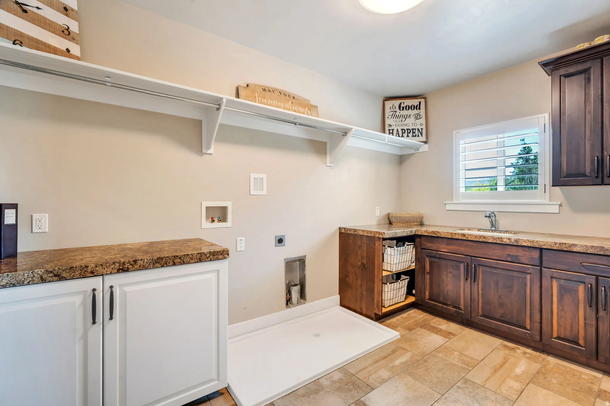 Utility room featuring a built-in sink, stone-finish countertops, wood-finish cabinetry, and tiled flooring