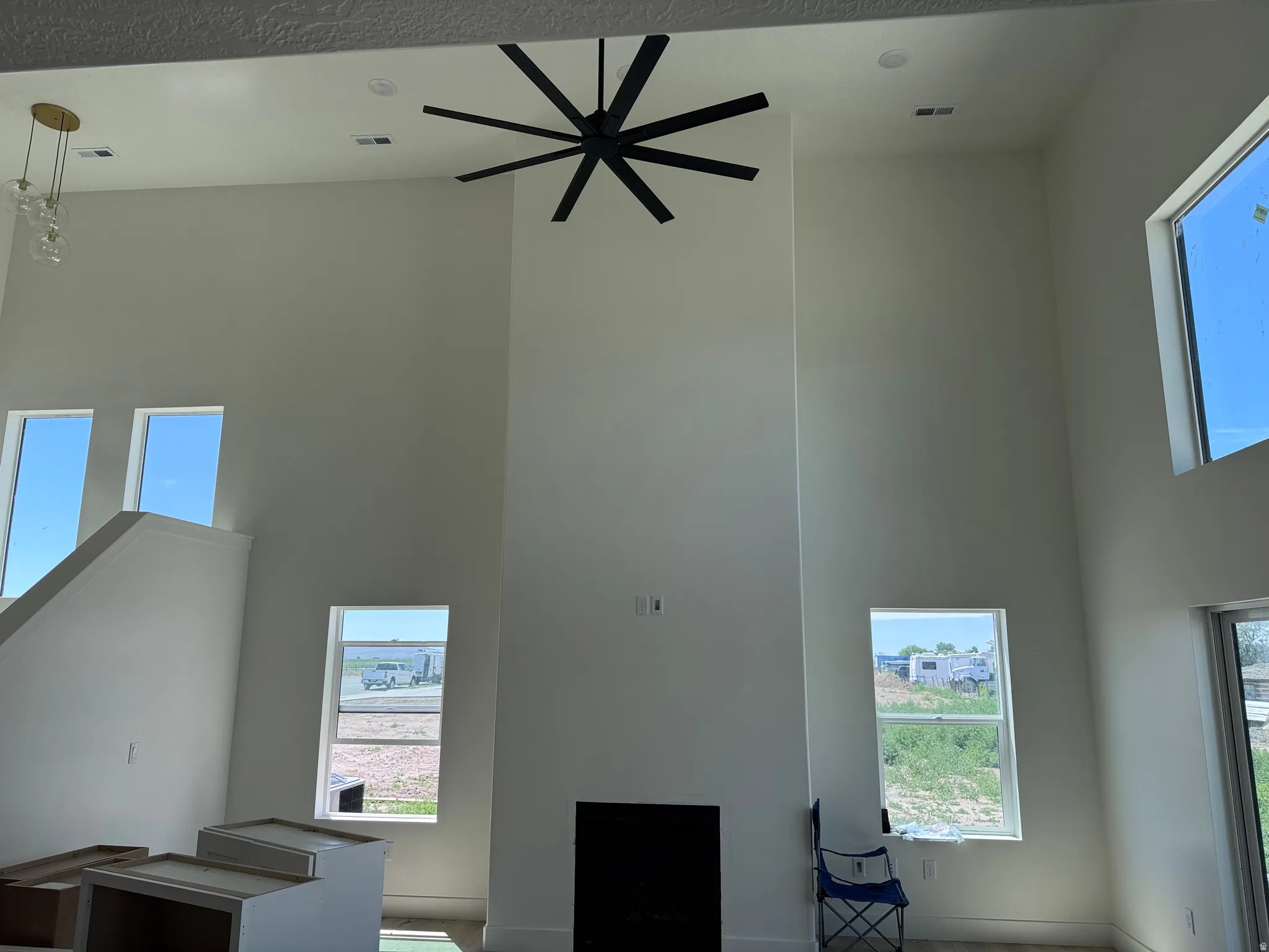 Vaulted ceilings with a prominent fireplace feature and a large modern ceiling fan