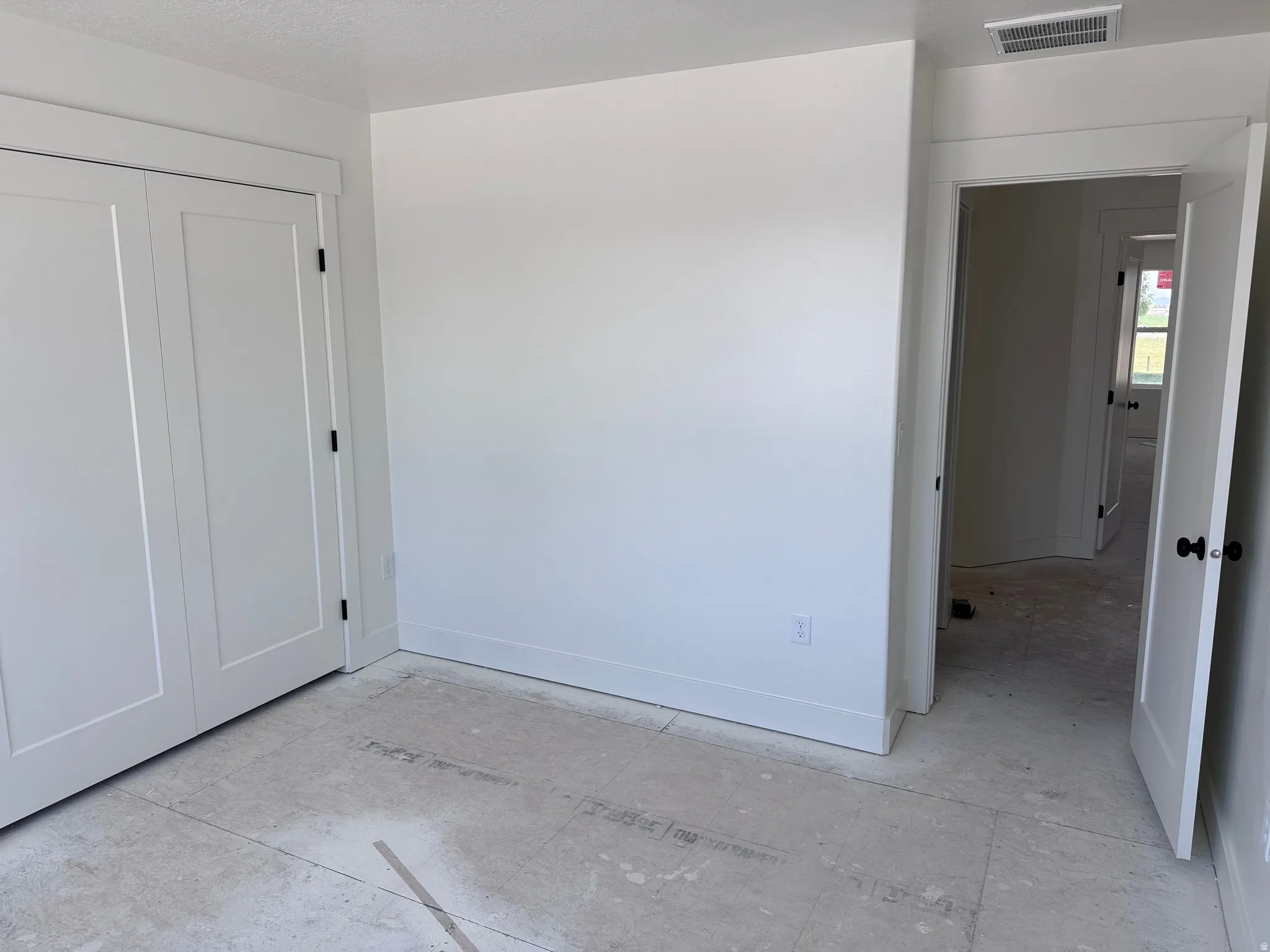 Unfinished room featuring white walls, white baseboards, and white trim throughout
