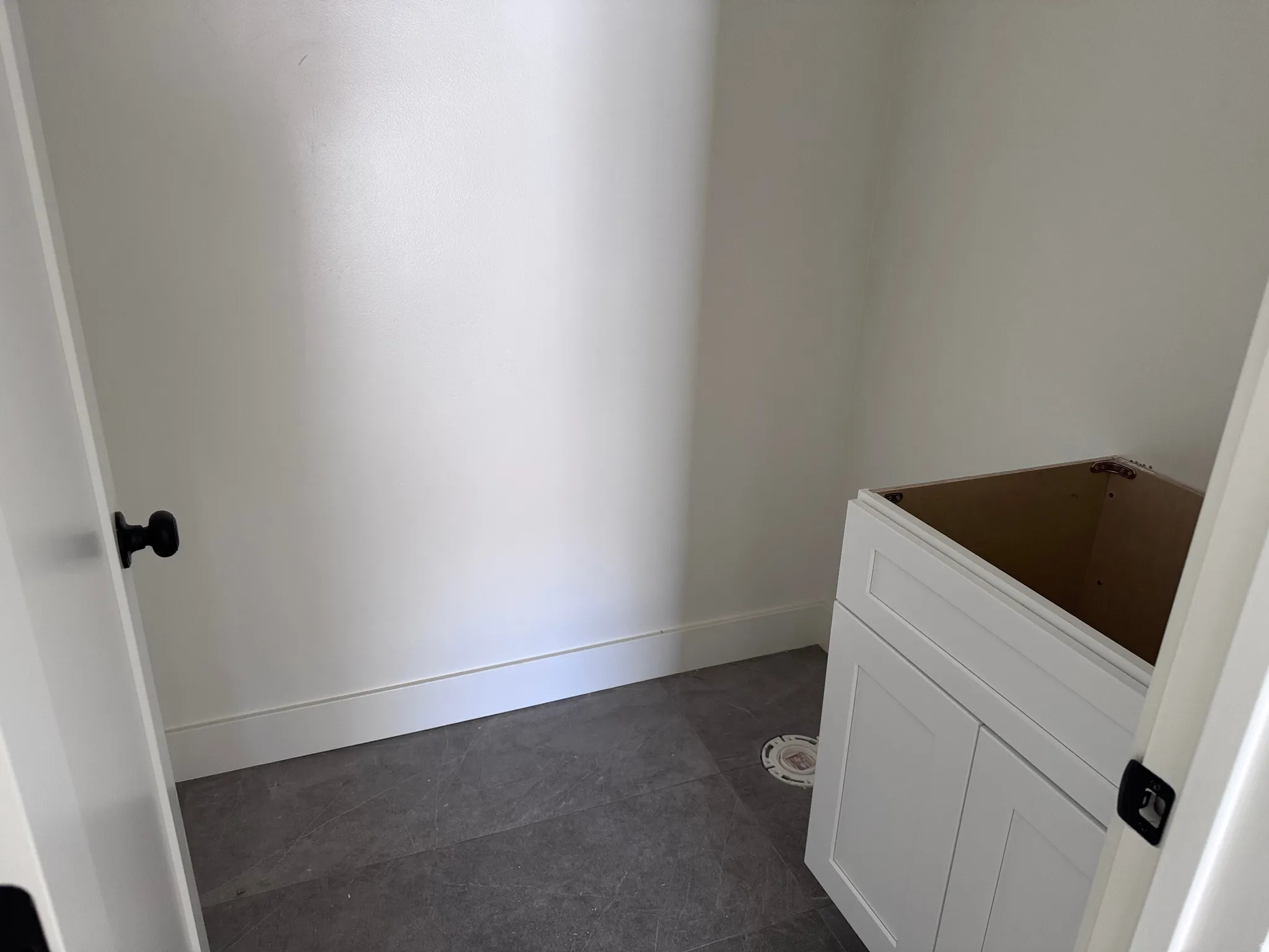 Room featuring dark grey floor tiles and white baseboards