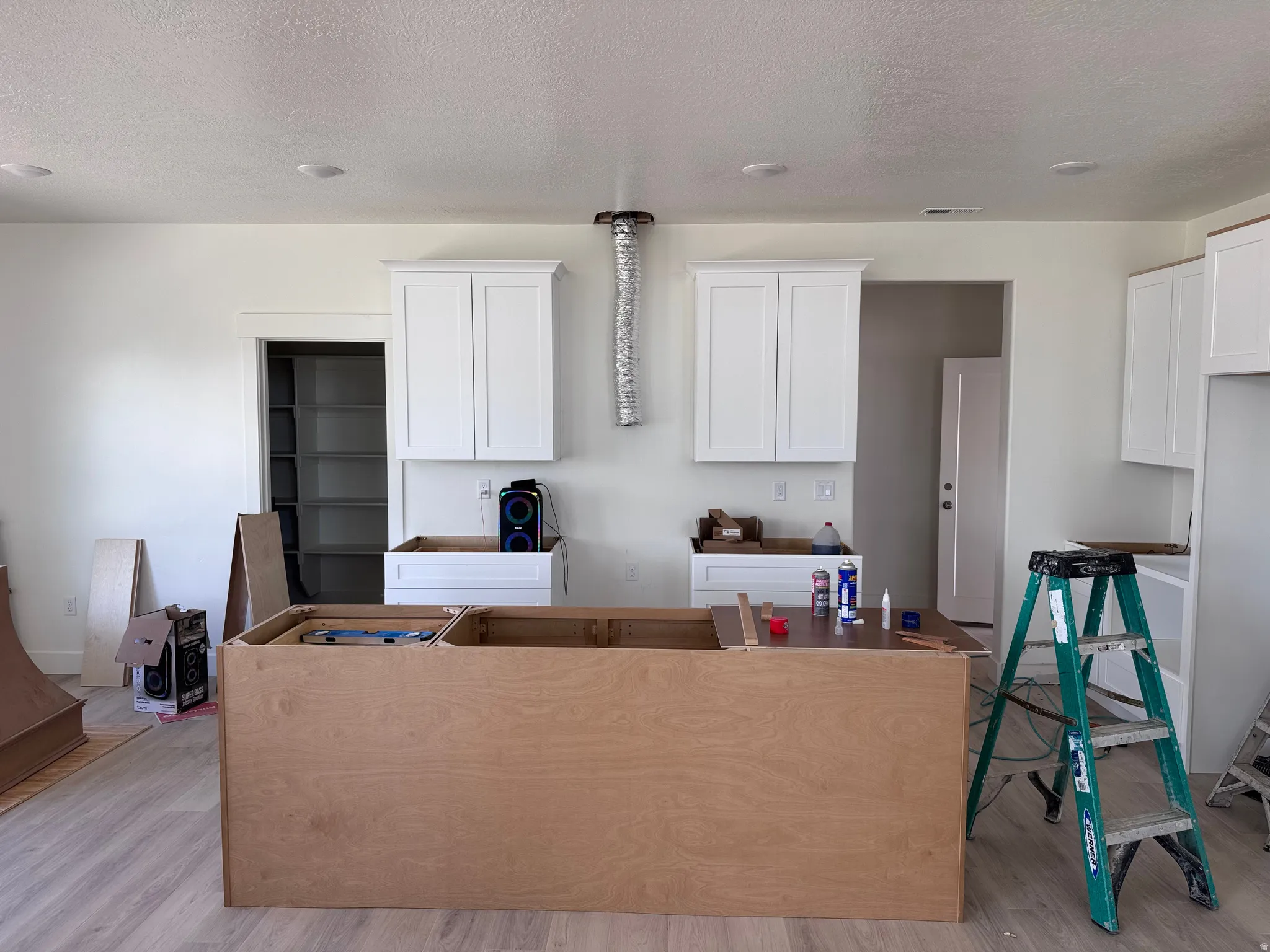 Kitchen space featuring light wood-finish flooring and recessed ceiling lighting