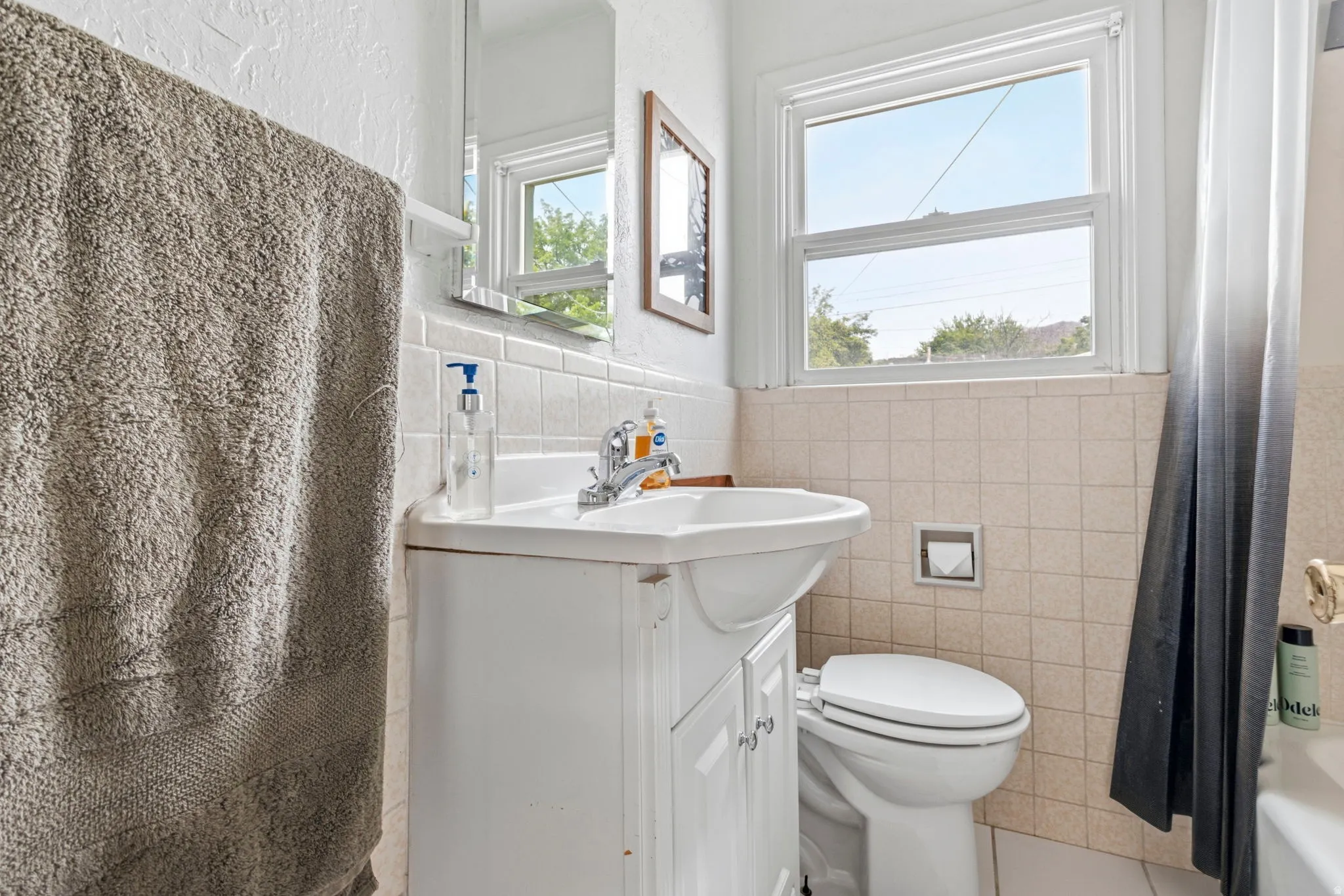 Bathroom featuring a white vanity with integrated sink, chrome faucet, and a wall-mounted medicine cabinet