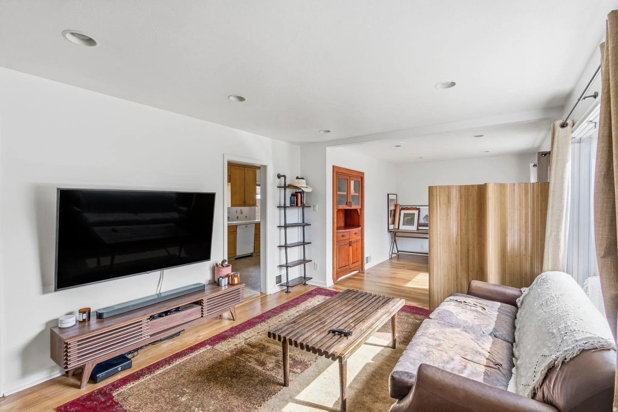 Open-concept living space with recessed lighting, wood-finish flooring, and crisp white walls