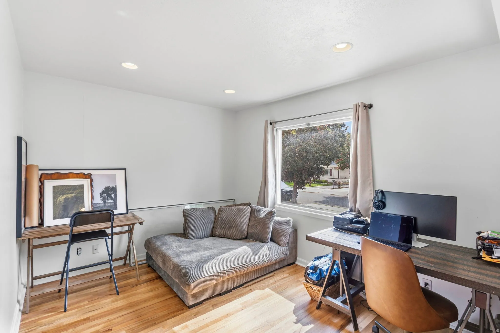 Bright room featuring wood-finish flooring, recessed lighting, and a large window with natural light