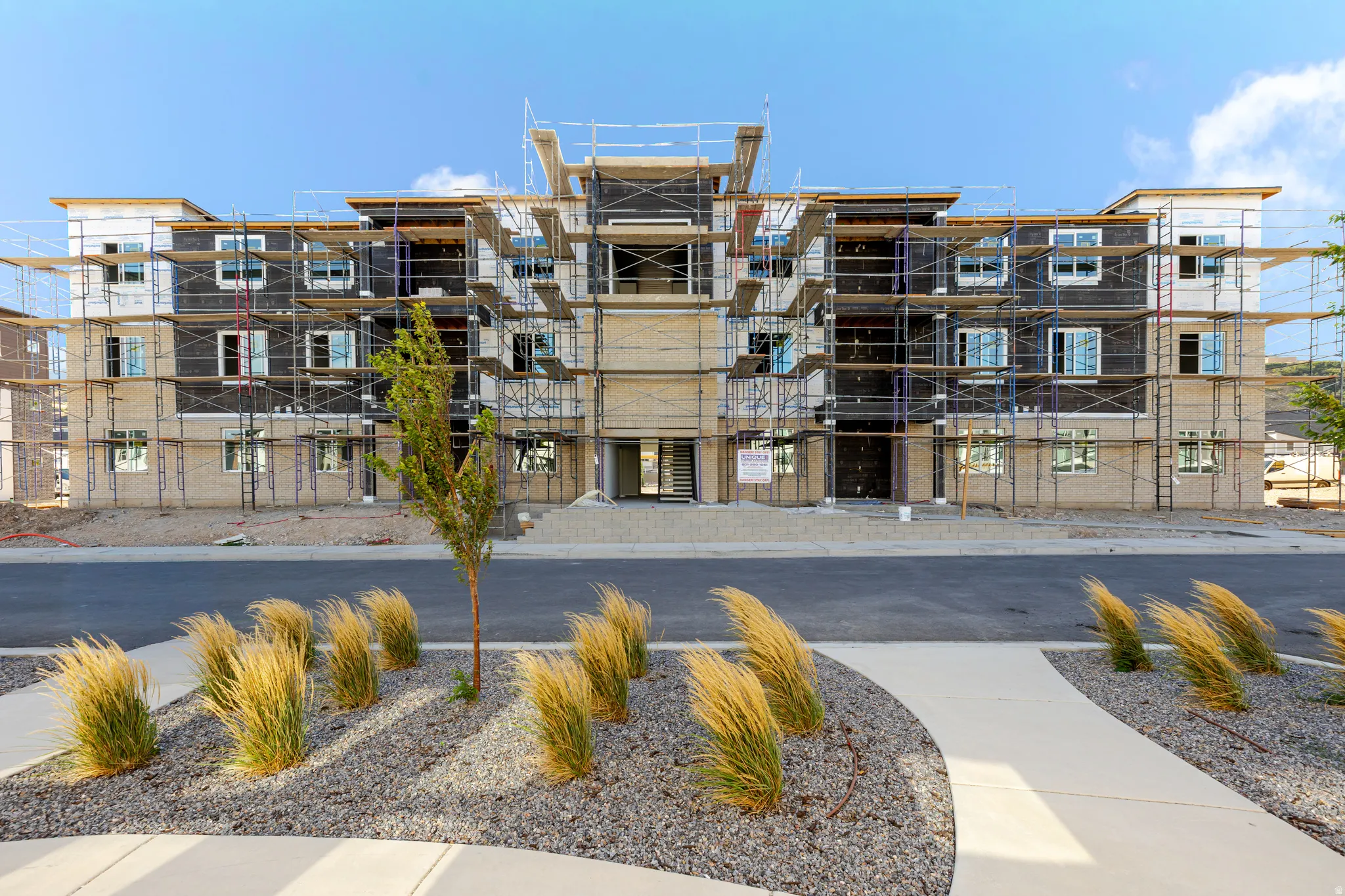 Contemporary multi-unit residential building featuring a striking architectural facade with mixed material finishes including brick and stone cladding