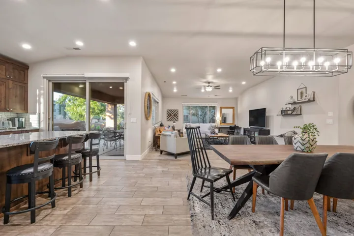 Dining area featuring a ceiling fan, wood tiled floors, vaulted ceiling, and recessed lighting