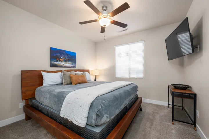 Carpeted bedroom featuring a ceiling fan and baseboards