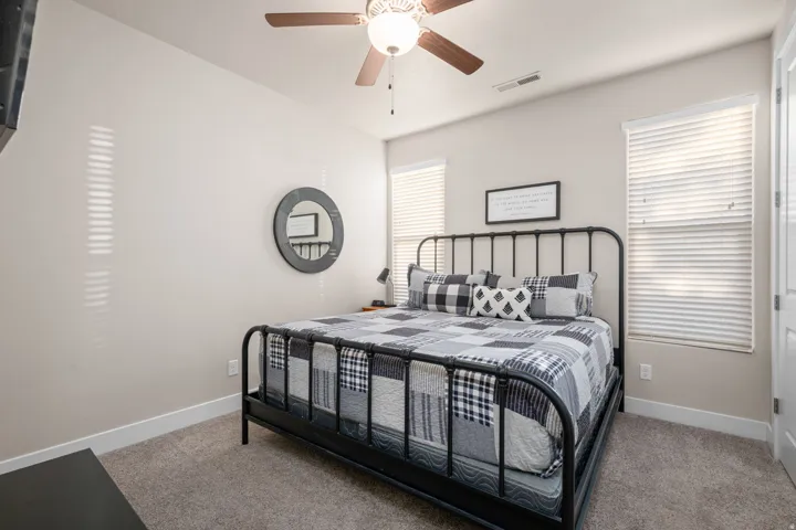 Bedroom featuring a ceiling fan and light colored carpet