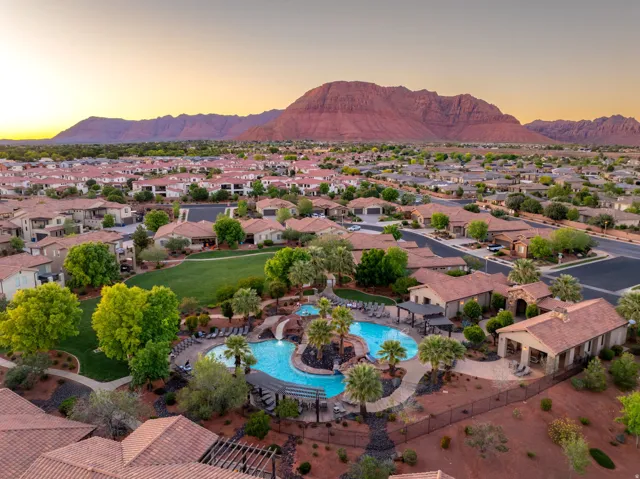 Aerial view at dusk of a mountain view, view of pool, and a residential view