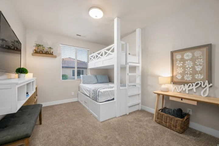 Bedroom featuring baseboards and light carpet
