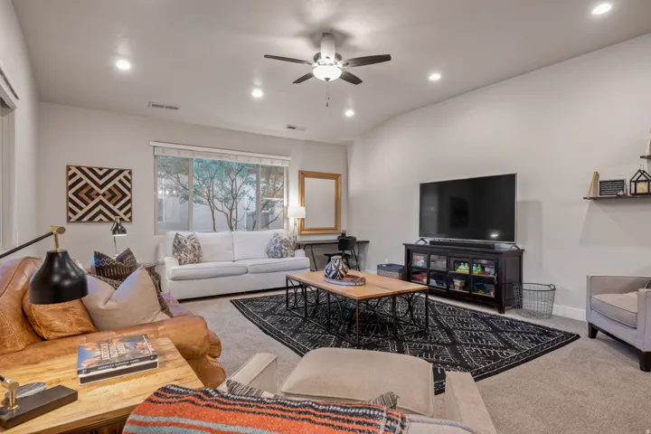 Living room with carpet flooring, ceiling fan, and recessed lighting