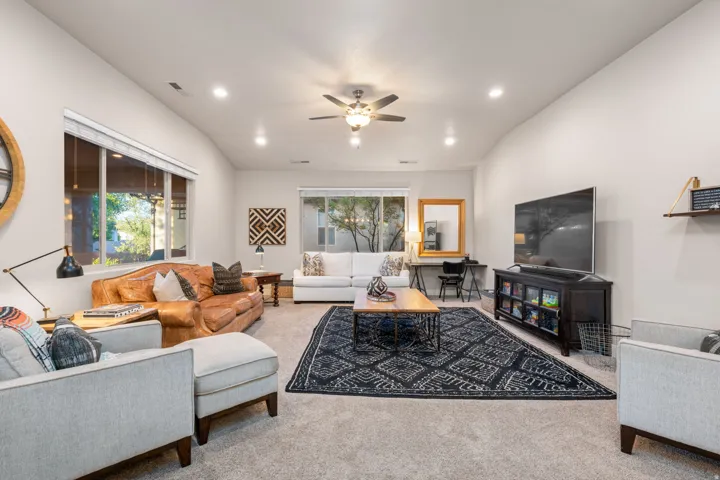Living area with carpet flooring, a ceiling fan, and recessed lighting