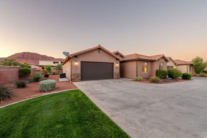 Mediterranean / spanish house with an attached garage, stucco siding, concrete driveway, stone siding, and a tile roof