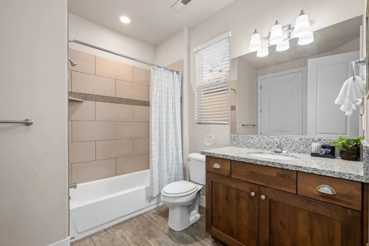 Bathroom with vanity, wood finish floors, and shower / tub combo