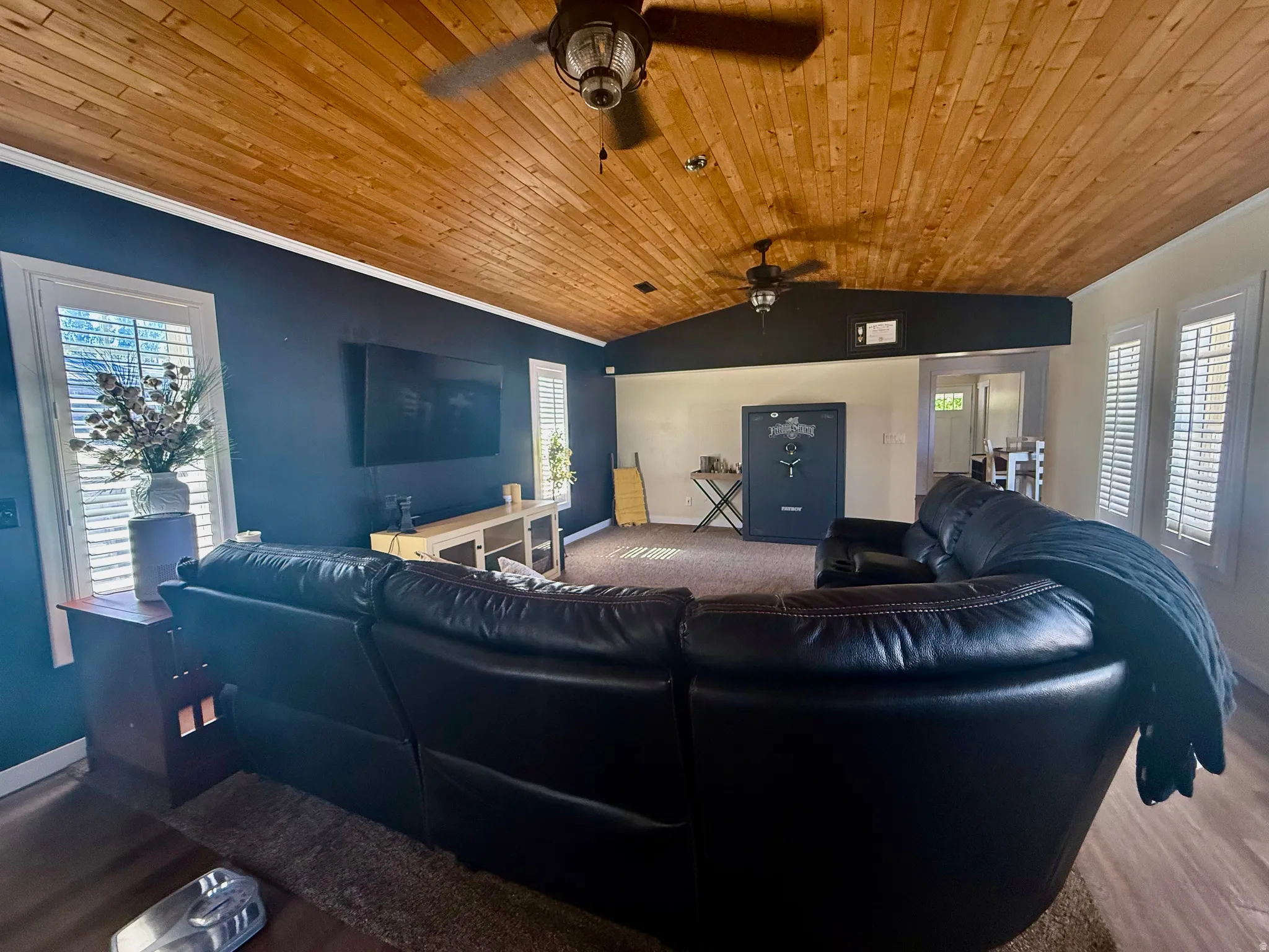 Vaulted wood-finish plank ceiling with dual ceiling fans