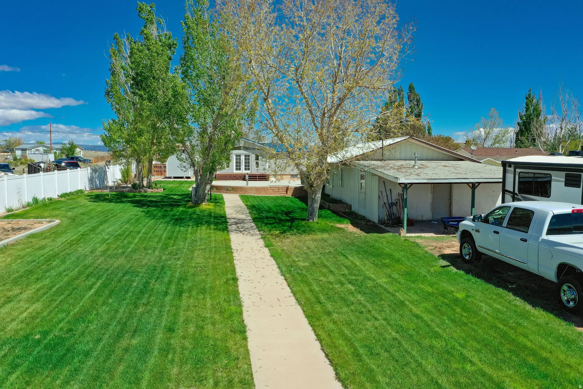 Expansive front yard with a concrete pathway leading to the residence