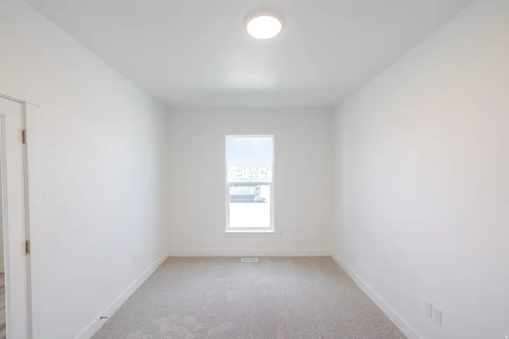 Recessed ceiling light fixture, framed window, carpeted flooring, and white painted walls