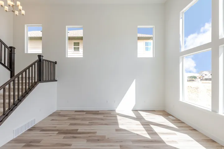 Wood-finish flooring throughout, complemented by a dark wood staircase with matching railings