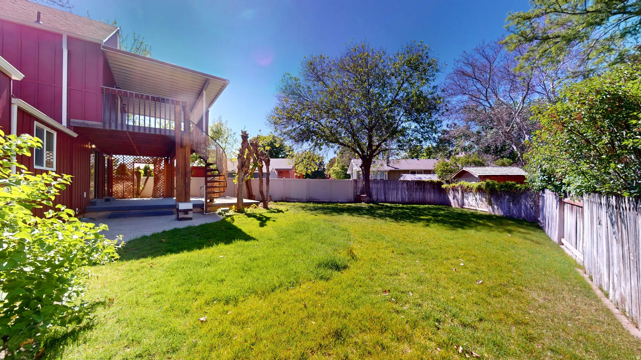 Expansive green lawn with a privacy fence