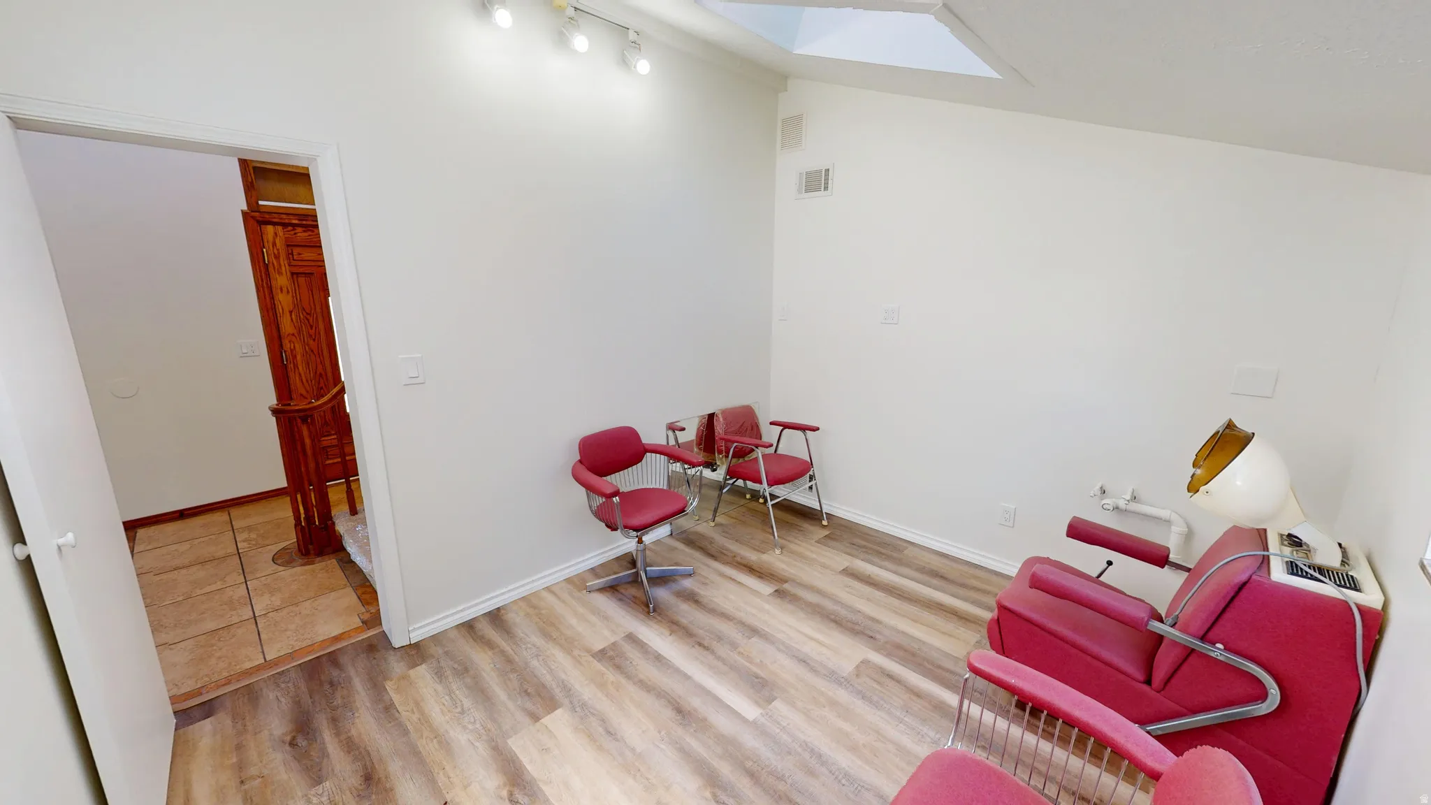 Salon. Room featuring wood-finish flooring and white walls