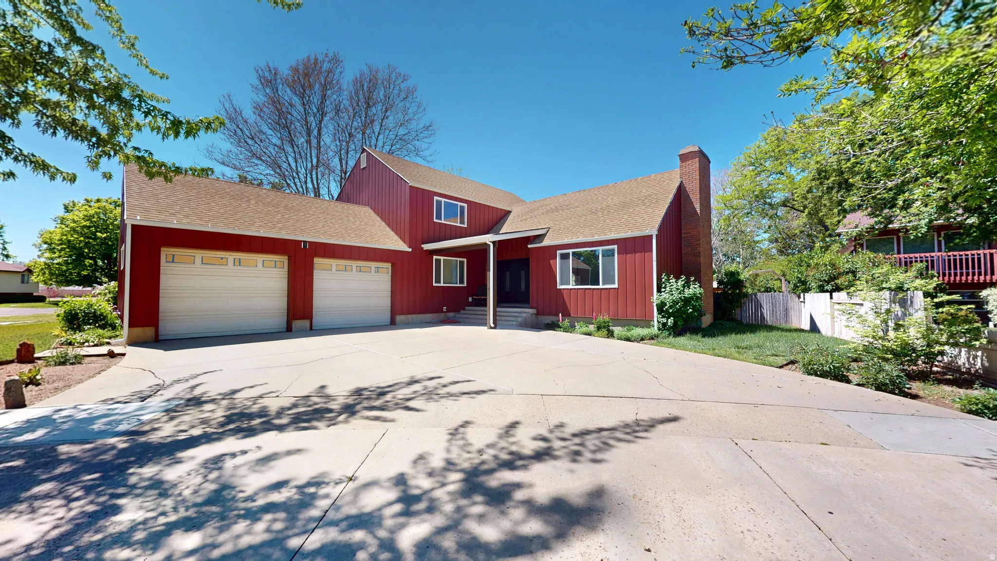 Red-sided home with a concrete driveway and an attached two-car garage