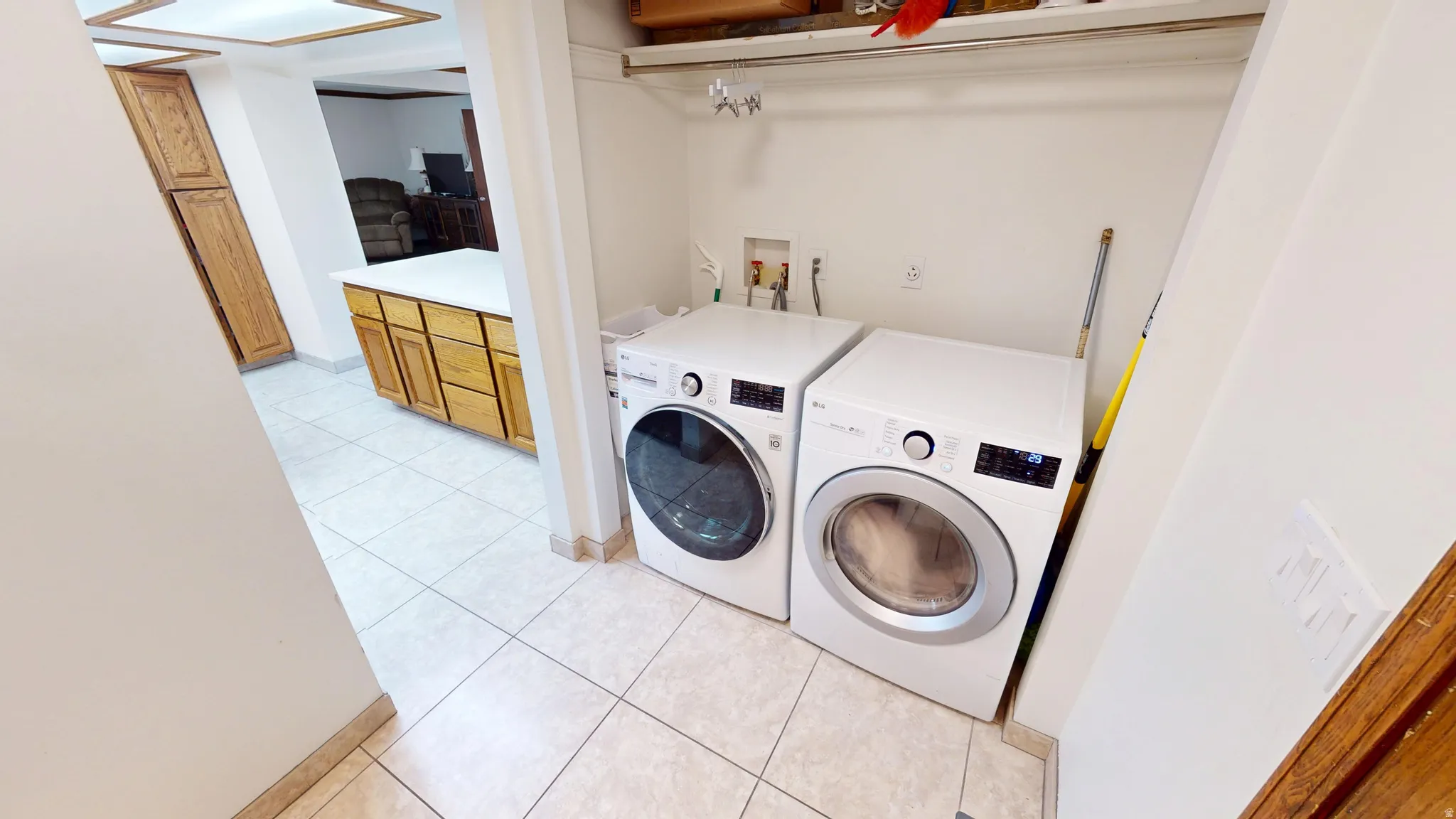 Dedicated laundry area featuring a white tiled floor and a built-in shelf