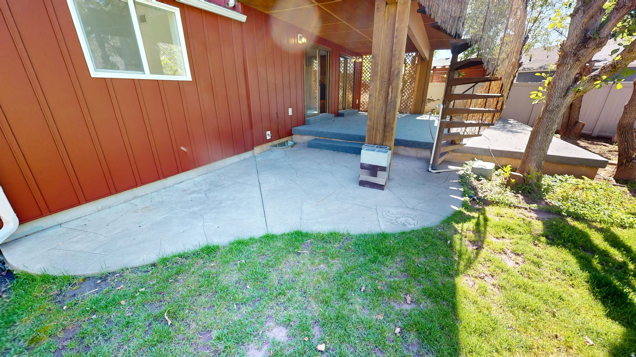 Stamped concrete patio featuring a covered area with exposed wood beams