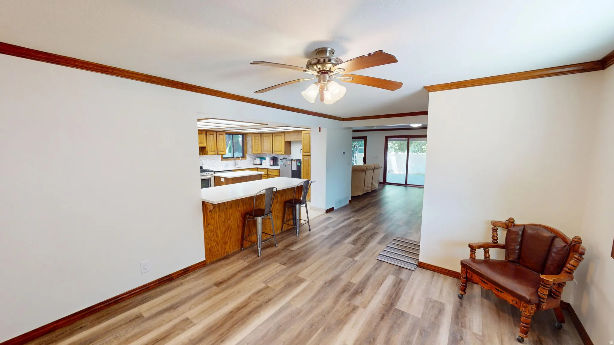 Open-concept living area featuring wood-finish flooring and a ceiling fan with integrated lighting