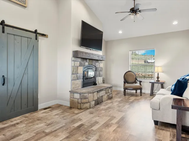 Stone-clad fireplace with a hearth and wood-finish mantel