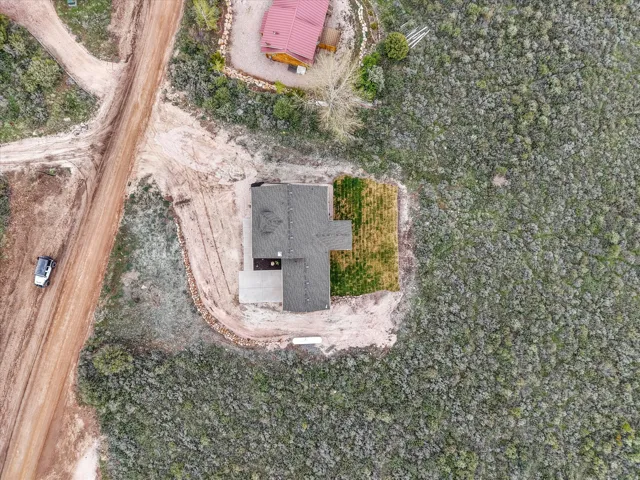Newly constructed residence featuring a dark shingle roof and a concrete driveway