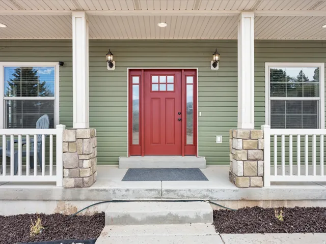 Inviting front entrance featuring a vibrant red door with glass sidelights and transom window