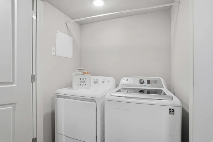 Dedicated laundry area featuring a top-load washing machine and a front-load dryer