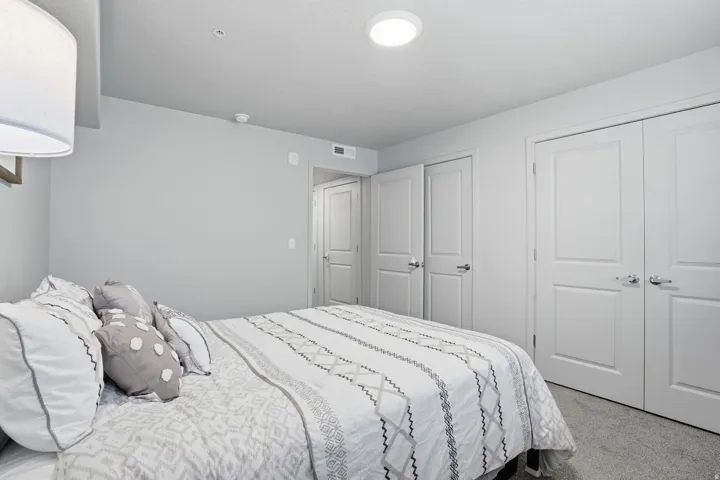 Bedroom featuring light gray wall paint, textured carpet flooring, and recessed ceiling lighting