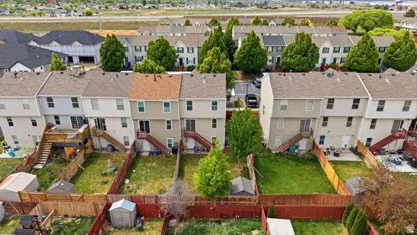 Rear exterior showcasing private fenced backyards with mature trees and ground-level patios