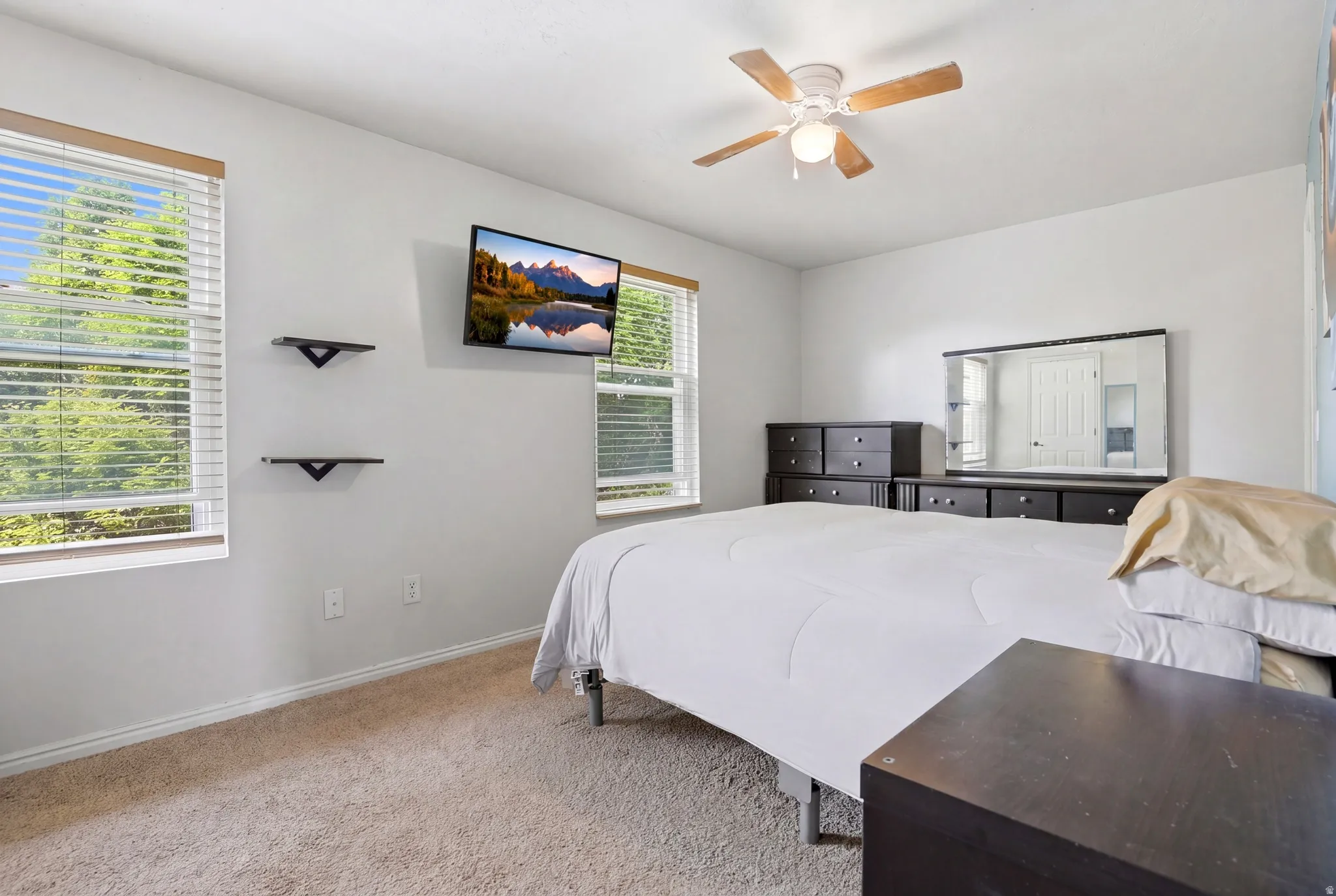 Carpeted room with a ceiling fan light fixture