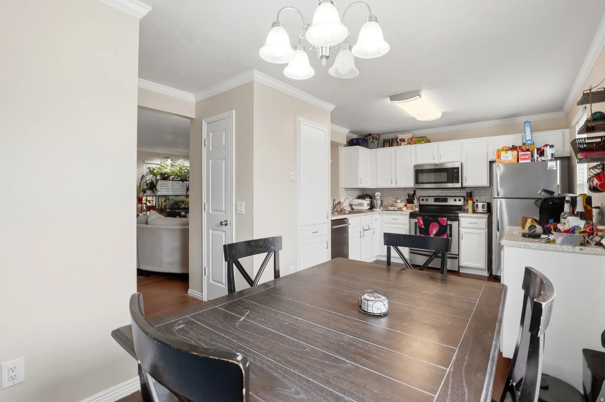 Dining area with wood-finish flooring and a decorative chandelier