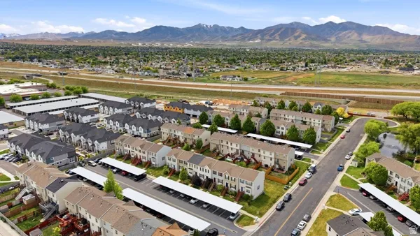 Contemporary townhome community featuring diverse architectural styles, structured parking facilities, and a manicured streetscape