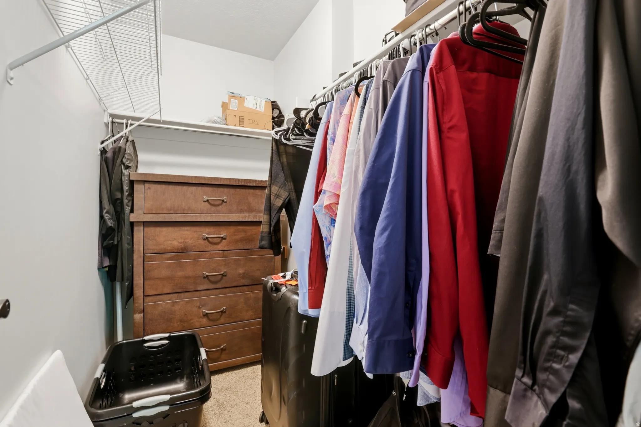 Walk-in closet featuring wire shelving, a built-in hanging rod, and ample storage space