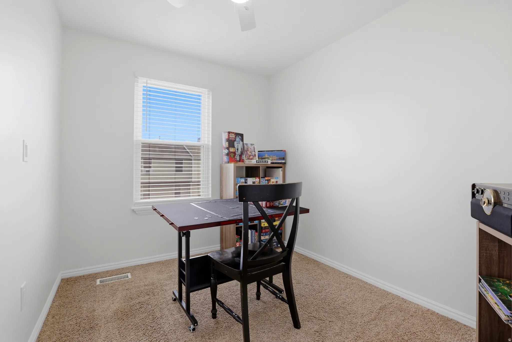 Carpeted room with a ceiling fan, a window featuring blinds, and white baseboards
