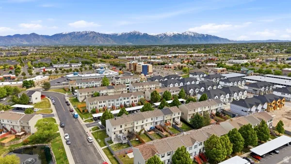 Expansive aerial perspective showcasing a residential community with distant snow-capped mountains