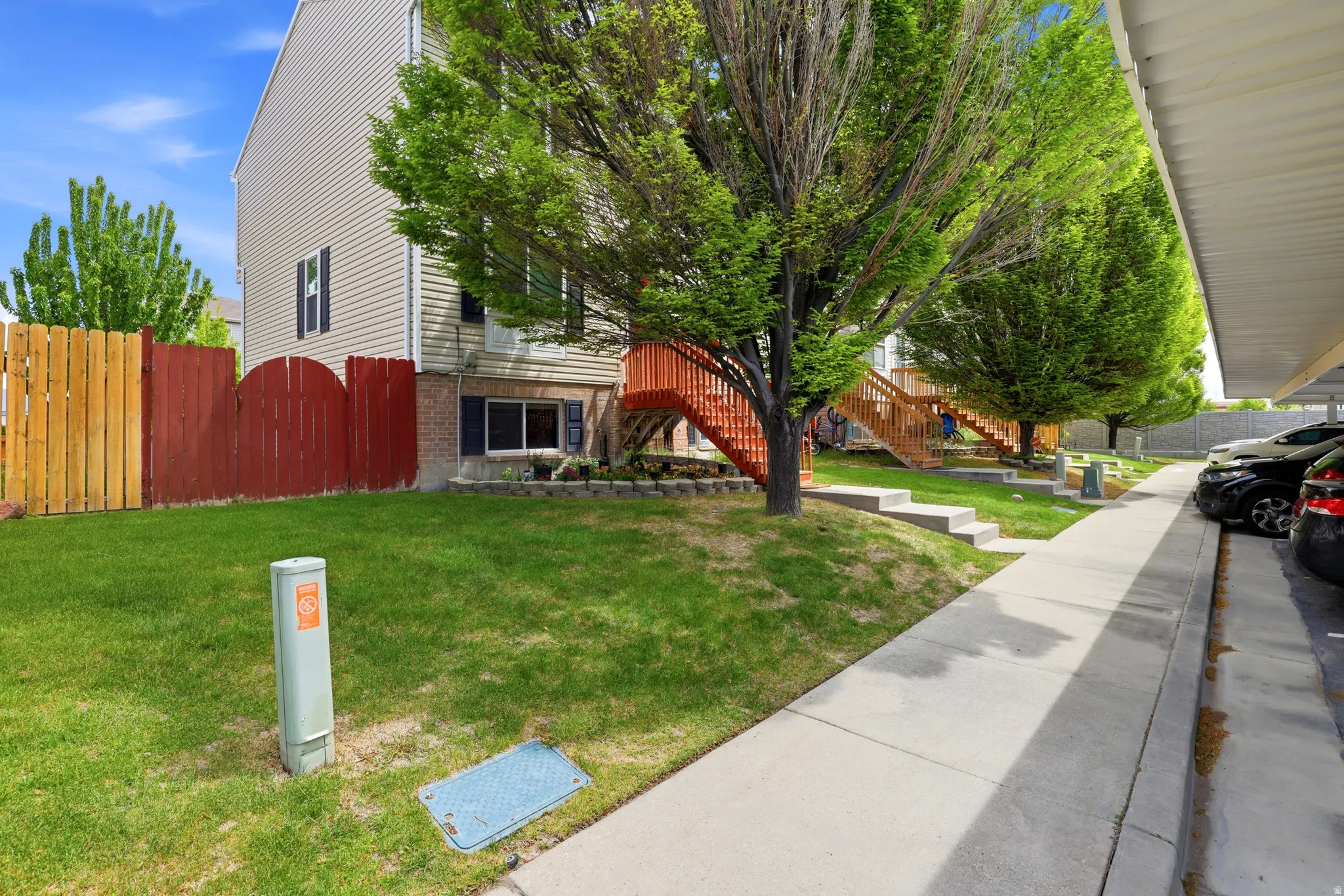 Exterior featuring horizontal siding, dark shutters, and a contrasting red stained fence