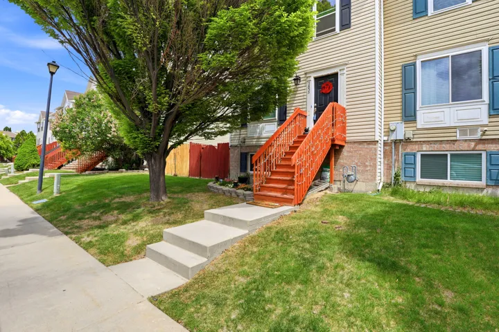 Townhome exterior with light-colored siding and a dark entry door