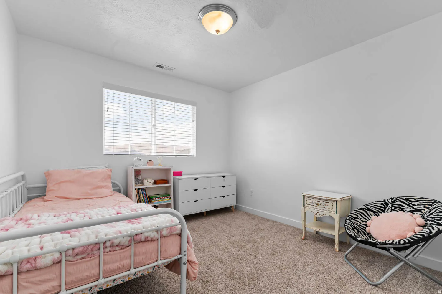 Room featuring a single window with horizontal blinds, neutral carpet flooring, and white painted walls