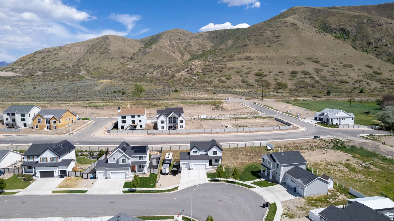 Contemporary residential development featuring cul-de-sac streets, newly constructed homes, and mountain backdrops