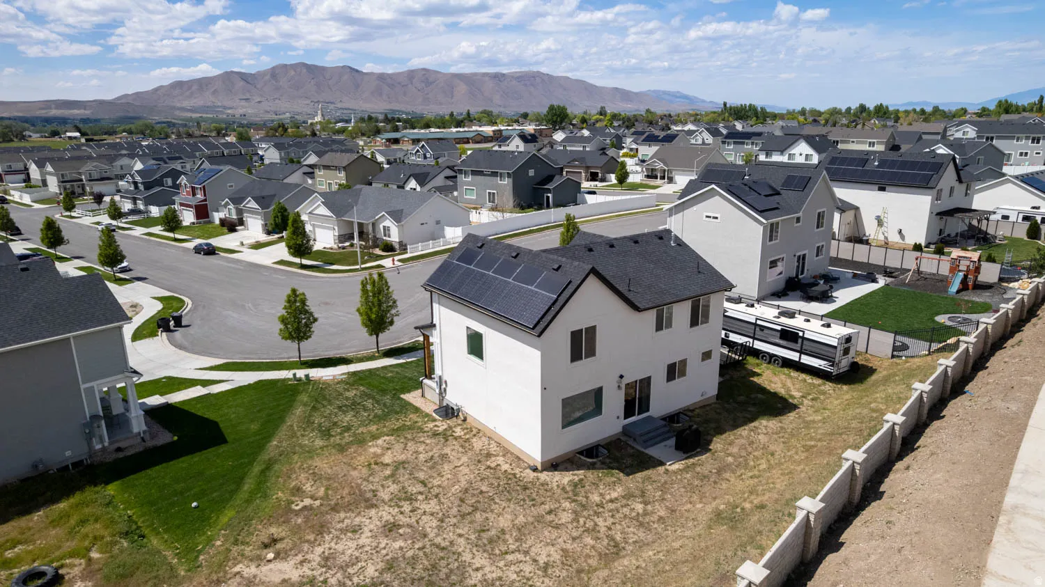 Contemporary two-story residence featuring a dark shingle roof and solar panels